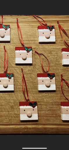 several ornaments are arranged on a wooden table with ribbon around them and attached to tags