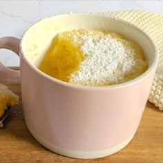 a cup filled with powdered sugar next to a spoon