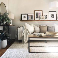 a living room filled with furniture and pictures on the wall