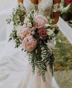 a bride holding a bouquet of flowers on her wedding day