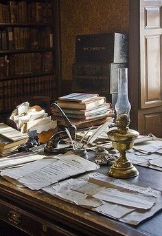 an old desk with many books and papers on it