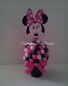 a minnie mouse cake topper with pink and white pom - poms on it