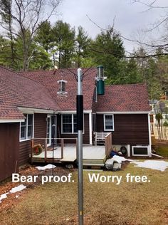 there is a sign that says bear proof worry free in front of a house with snow on the ground