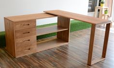 a wooden desk sitting on top of a hard wood floor next to a green grass covered wall