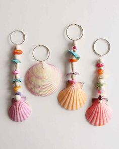 three seashells are hanging on the wall next to each other with beads and charms