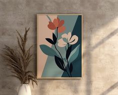 a vase with some flowers in it next to a wall mounted art piece on the wall