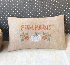 an embroidered pillow with pumpkins on it