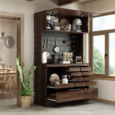 an open cabinet with utensils on it in a room next to a potted plant