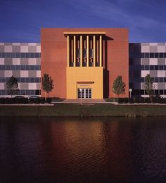 an orange building sitting next to a body of water