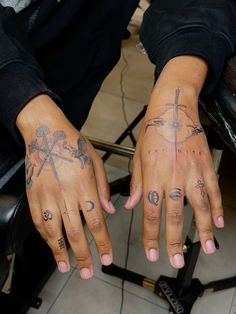 two hands that have tattoos on them