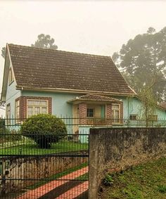 a blue house behind a fence in the rain