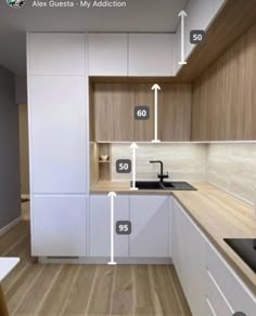 a kitchen with white cabinets and wood flooring has numbers on the wall to indicate where they are located