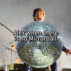 a man holding a disco ball in front of his face with the words alex when there is no mirrorball