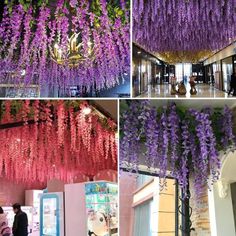 purple flowers are hanging from the ceiling in this store, and people are looking at them