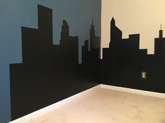 an empty room with black and blue wallpaper in the shape of cityscapes