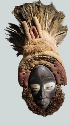 an african mask with feathers on it's head