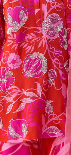 the back of a woman's red dress with pink flowers on it