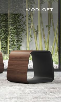 two modern chairs sitting next to each other in front of bamboo plants and windows with the word modloft on it