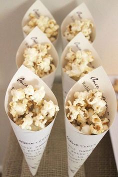 four cones filled with popcorn sitting on top of a table