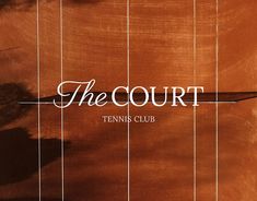 the court tennis club logo on an orange wood surface with white lines and shadows over it