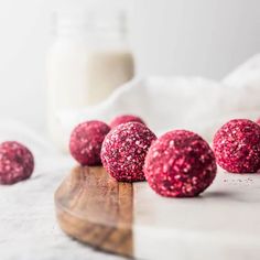 red velvet cookies on a wooden board next to a glass of milk