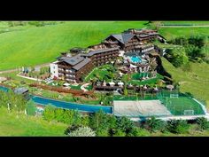 an aerial view of a large house with a pool and tennis court in the foreground