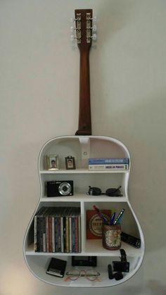 a guitar shaped shelf with books and other items