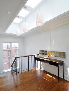 an empty room with wooden floors and white walls, has a skylight above the counter