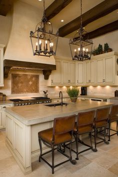 a large kitchen with an island and chandelier hanging from it's ceiling