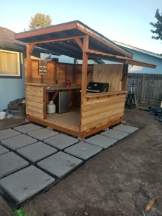 an outdoor bbq with a grill built into the side of it and covered in wood