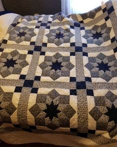 a bed with a black and white quilt on it