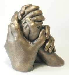 a bronze sculpture of a person holding their hands together