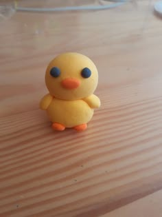 a yellow toy duck sitting on top of a wooden table