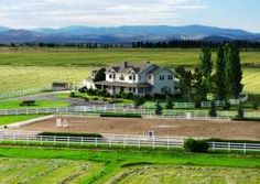 an aerial view of a horse farm with mountains in the background