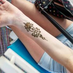 a woman's arm with a henna tattoo on her left wrist and the word love written in cursive writing