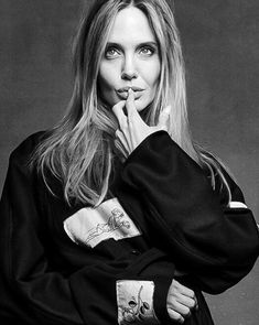 a black and white photo of a woman with her hand on her chin