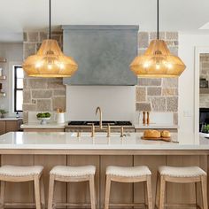 a kitchen with an island and four stools in front of the countertop area