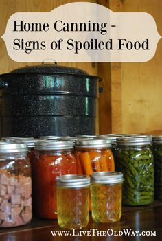 some jars filled with food sitting on top of a wooden table next to a pot