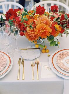 an arrangement of flowers and plates on a table