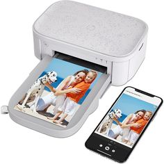 an iphone is next to a photo printer