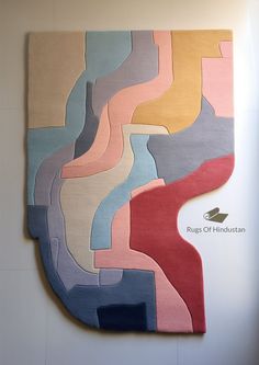 the rugs on the wall are designed to look like an abstract painting with different colors