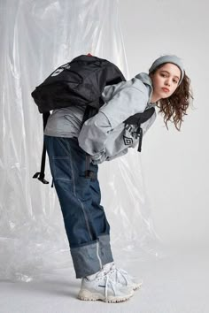 a young woman is posing with her back pack