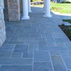 a stone walkway between two white pillars