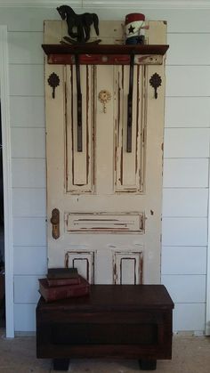 an old wooden bench sitting in front of a door with two books on top of it