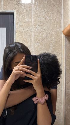 a woman taking a selfie in front of a mirror with her hands on her face