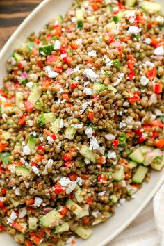 a white plate topped with a salad covered in cucumber and feta cheese