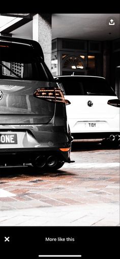 the back end of a car parked in front of a parking garage with other cars