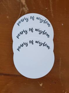 three white coasters with writing on them that say many of whom means of vision