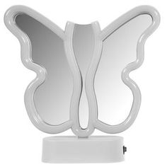 a white butterfly shaped mirror sitting on top of a table