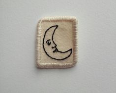 a small patch with a drawing of a crescent moon on it's back side